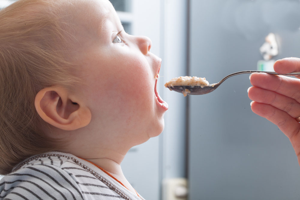 Part 2: Heavy Metals Found in Baby Formulas and Baby Cereals Mother feeds baby boy with a spoon porridge