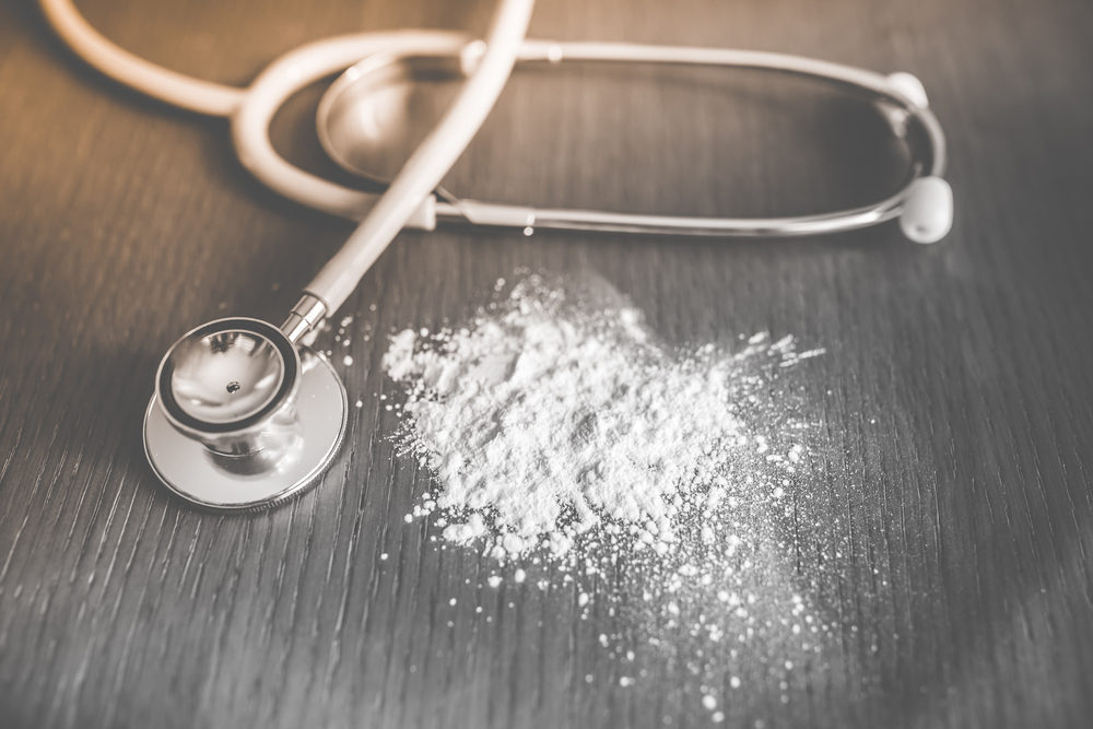 Judge Allows PA Talcum Powder Cancer Lawsuits to Proceed Baby talcum powder spilled on wooden table near stethoscope