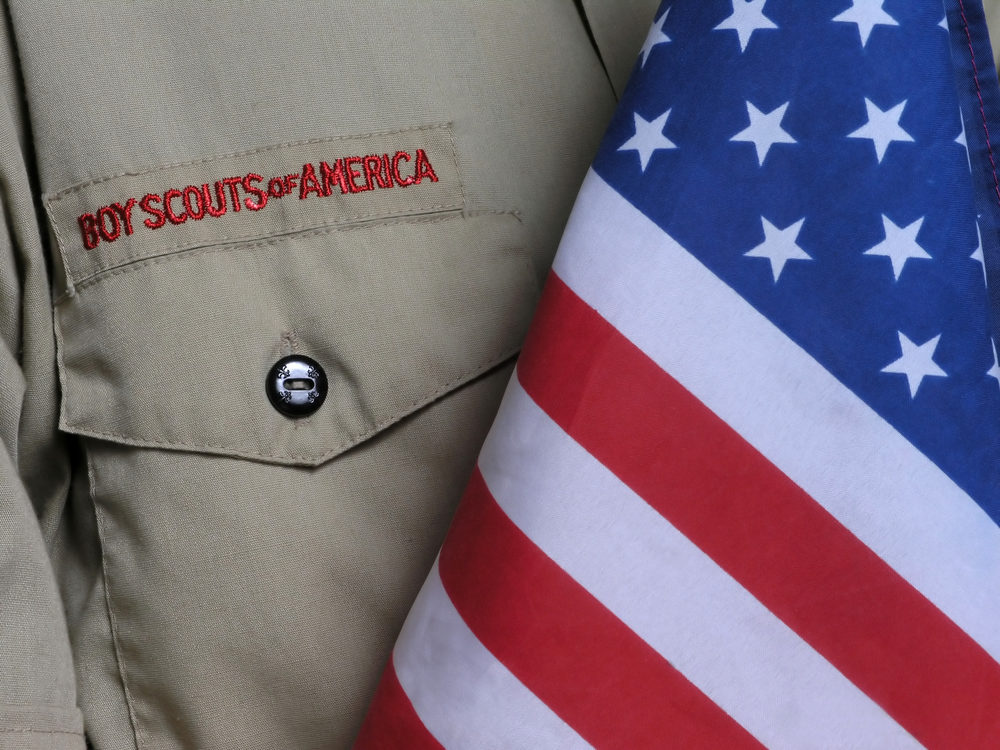 Judge Approves Settlement in Boy Scouts Bankruptcy Boy Scouts of America shirt beside a US flag