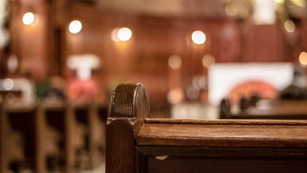Gary Keesee Jr., Son of New Albany Megachurch Leaders Arrested on Multiple Child Sexual Abuse Charges After Lengthy Probe back view of an interior church pew with blurred background