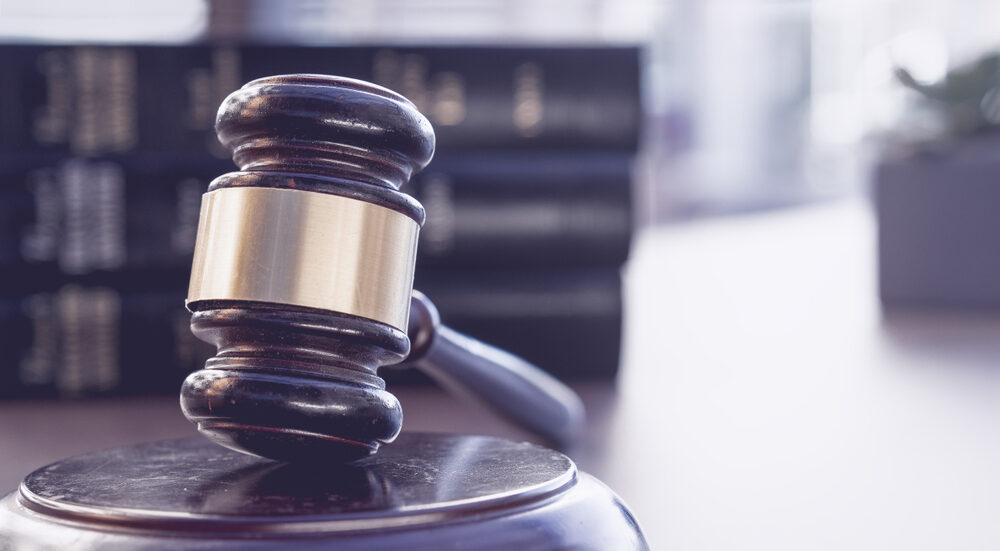 Top 10 Civil Justice Stories of 2023: Part II a closeup of a wooden gavel on a desk with blurred law books in background