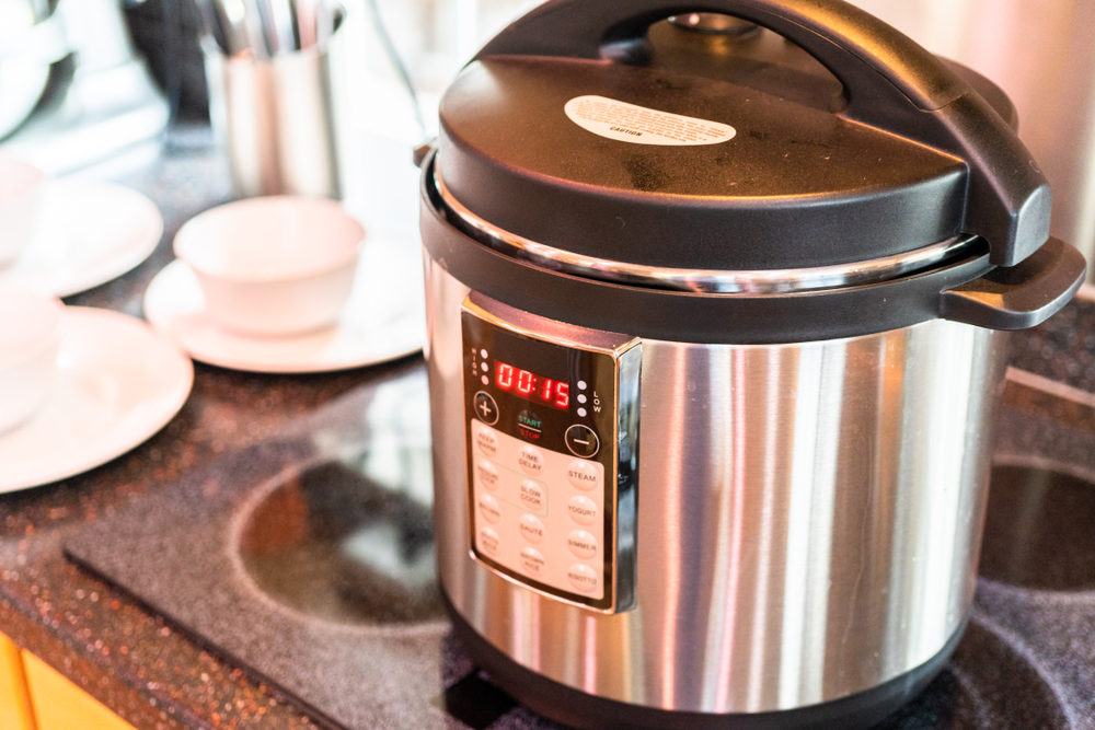 New Mexico Man Claims the Instant Pot Duo Defective, Caused Injuries Cooking dinner in a pressure cooker in a modern kitchen.