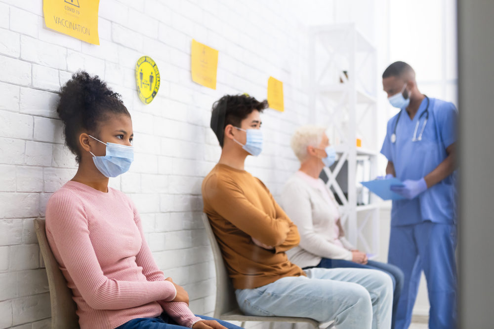 Diverse Patients People Waiting For Covid-19 Vaccine Sitting In Queue In Hospital Waiting-Room.