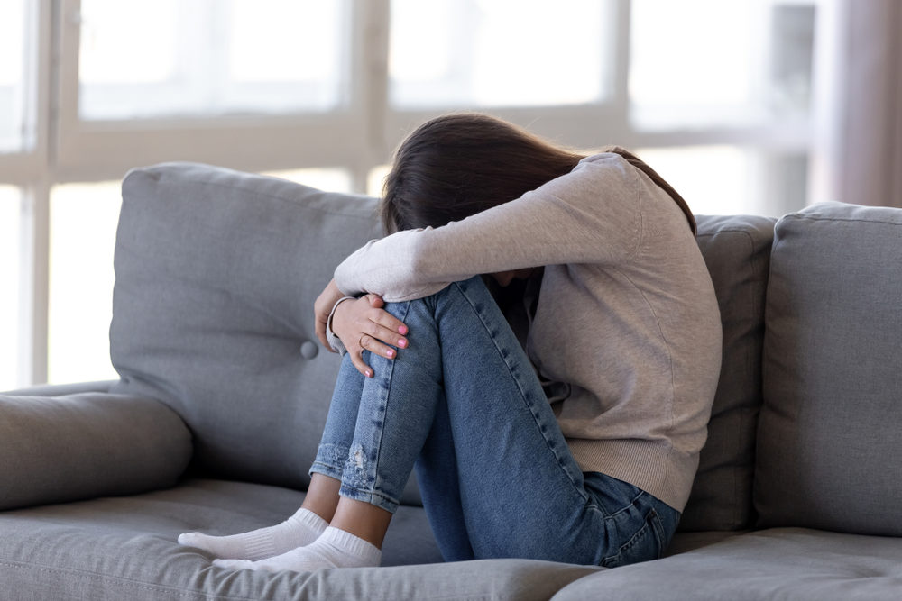 Federal Lawsuit Claims Eastern Michigan University Failed to Protect Students Depressed teen girl sitting on couch