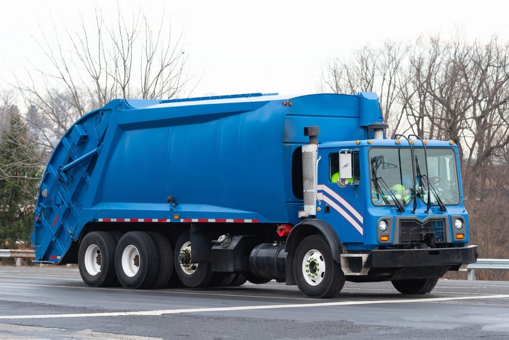 Tragic Death of 73-Year-Old Worker at Clifton Ricova Recycling Plant: OSHA Investigates Fatal Machinery Accident view of blue garbage truck on roadway
