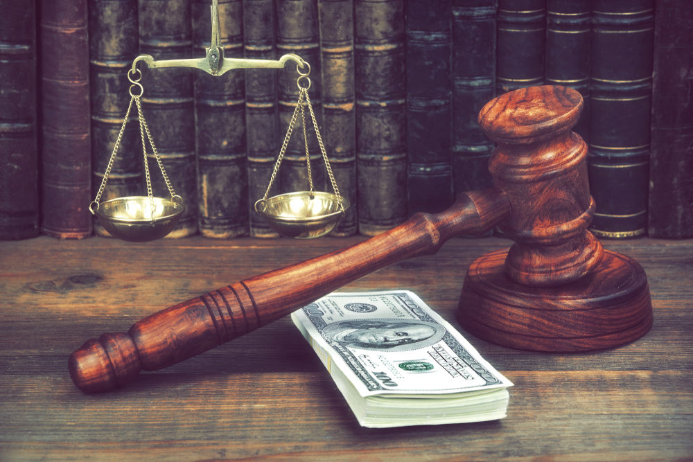 How Do I Prove Lost Wages After a Car Accident? gavel and scales on desk with a stack of USD in front of books