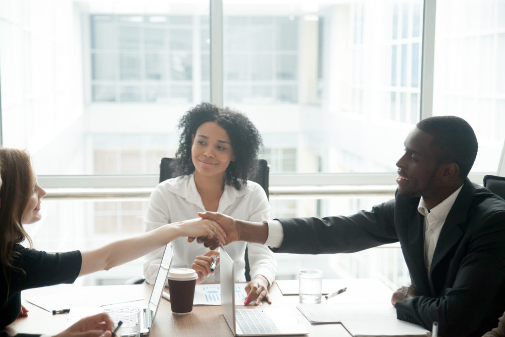How To Negotiate A Detroit Slip and Fall Settlement people shaking hands at desk with a mediator