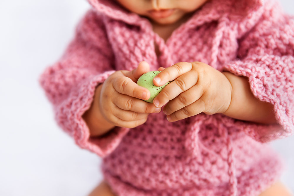 Airway Obstruction in Children Under Four – Injury Statistics and Incidence Rates Little baby girl in pink romper playing with green Easter egg