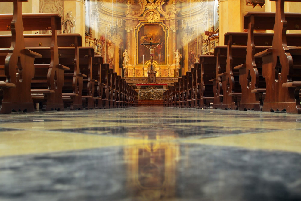 John O. McKay, Jr. Named in SBC Abuse Investigation Report Interior of a beautiful old catholic church from below with marble floor, wooden pews, and light streaming onto altar with Jesus on crucifix