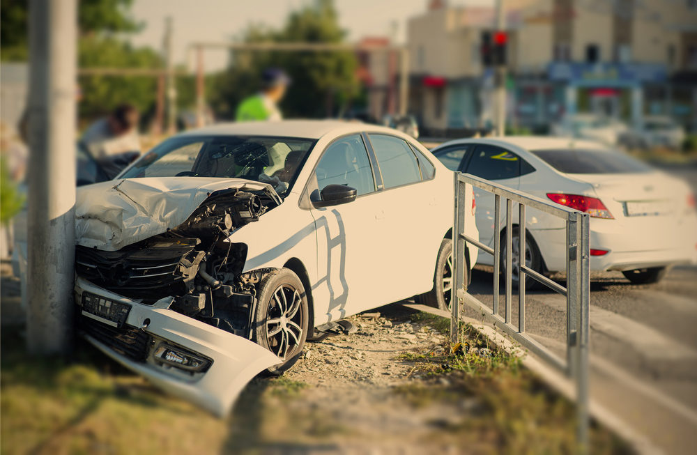 How Does a Virginia Car Accident Settlement Work? white car crashed into a light post on a city street