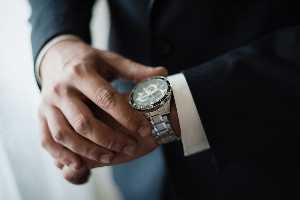 Bank of America Under Fire: 100-Hour Work Weeks Allegedly Linked to Employee’s Death Sparking Industry-Wide Scrutiny A man in a suit checking the time on his wrist watch