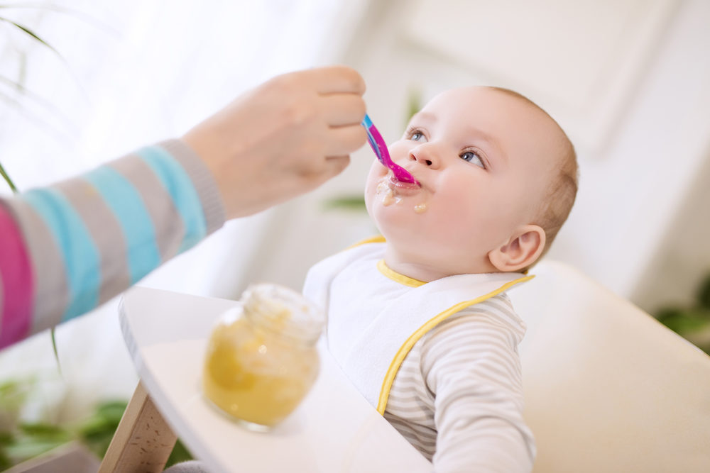 Congress Urges FDA to Move More Quickly to Limit Heavy Metals in Baby Foods Close up of a mother feeding her baby