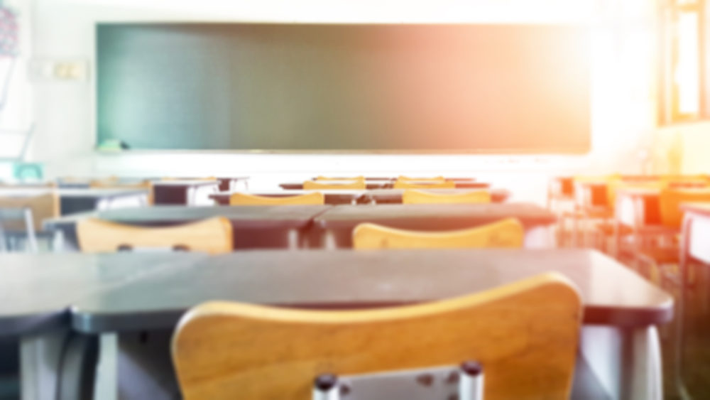 Richard Colon, Teacher Arrested for Obscene Material Distribution at Lake Mary High School blurred empty elementary school classroom with sunlight shining in
