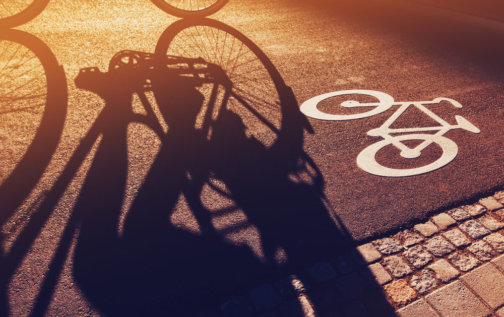 The Legal Maze of Dooring Bicycle Accidents in Virginia Shadow of unrecognizable cyclist riding a bike on bicycle lane