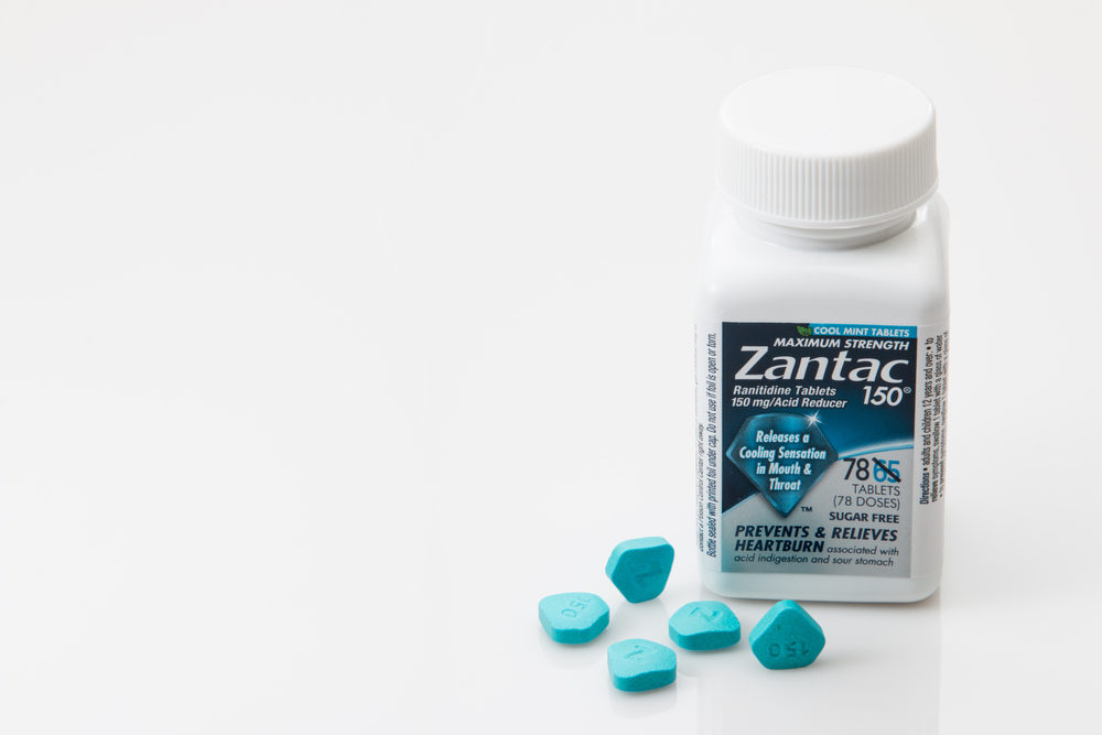 Zantac MDL Judge Sets Deadlines in Preparation for Early Trials A bottle of Zantac 150 with some blue pills beside it, on a white background