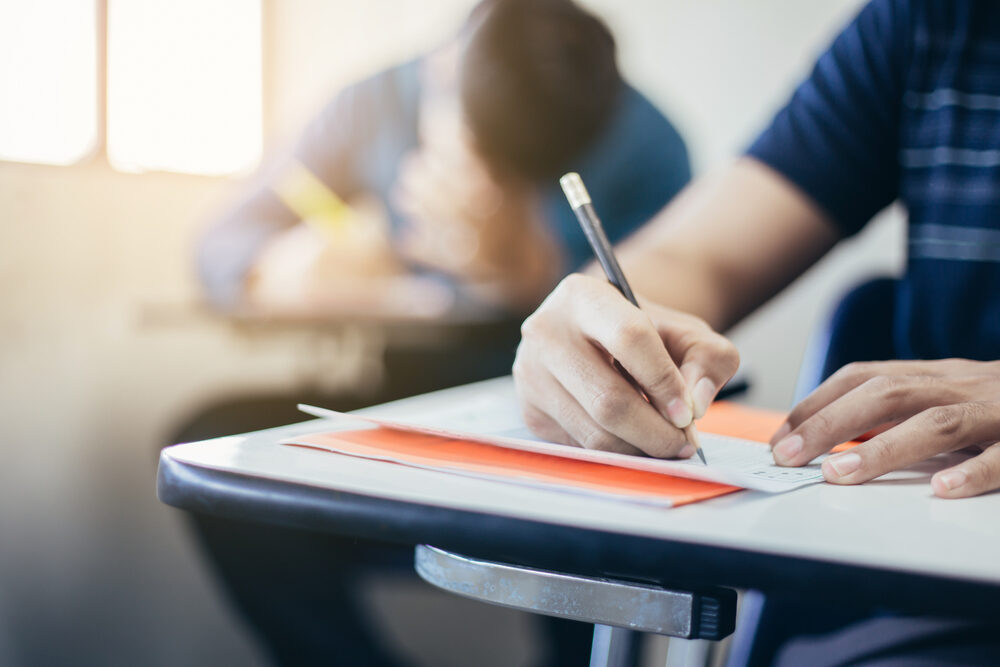Lennard High School Substitute Teacher, Joseph Prevatte, Arrested for Sexual Misconduct with Students in Two Counties male high school student at desk taking a test with pencil in hand
