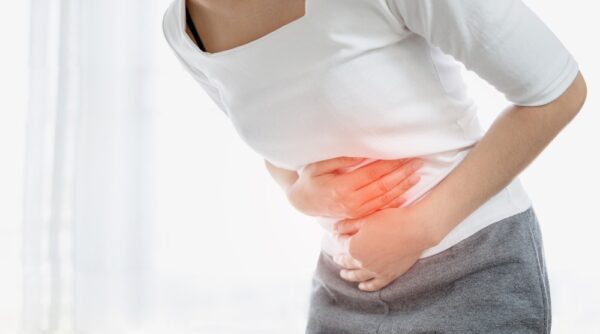 young woman holding her abdomen with painful menstrual cramps