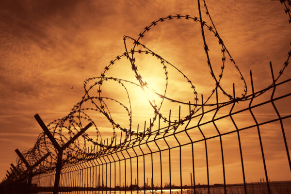 FCI Dublin prison barbed wire fence at sunset